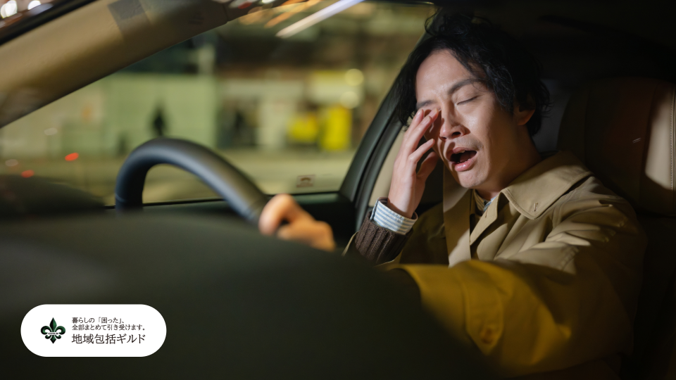 疲れながら運転をして、深くため息をつきながら落ち込んでいる子世代